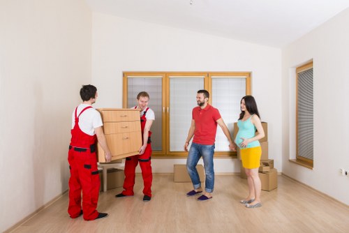 Careful movers navigating a Belsize Park street with packed boxes