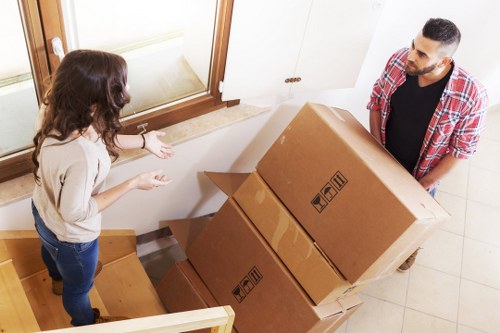 Moving crew transporting household furniture through a period property staircase